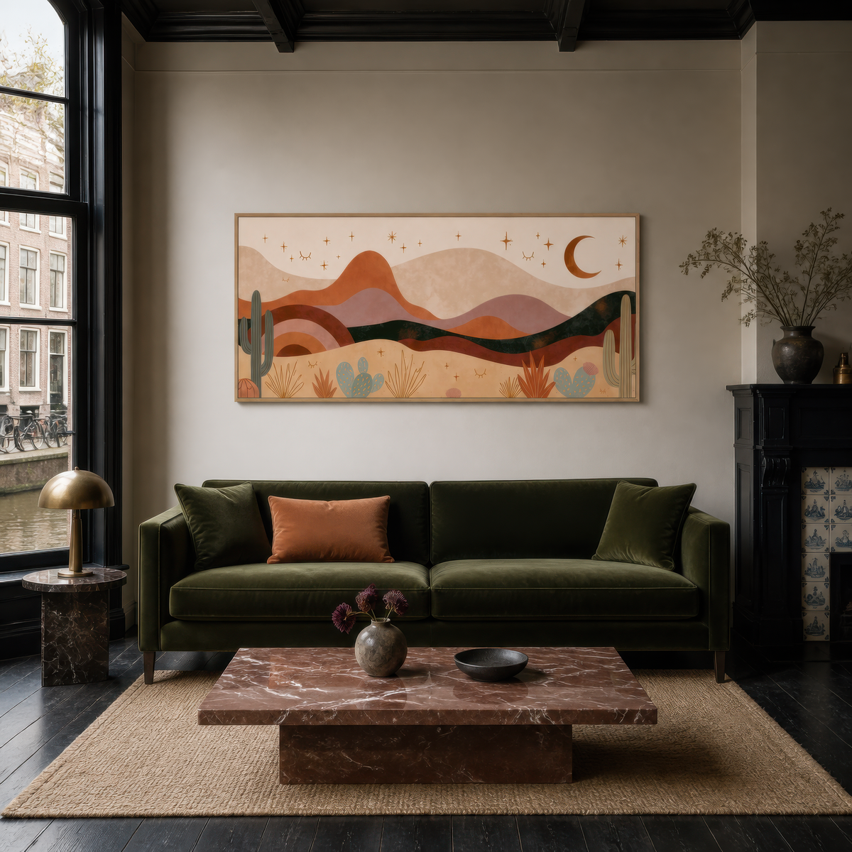 Desert night mountains above an olive green sofa in a dark room with a stone table