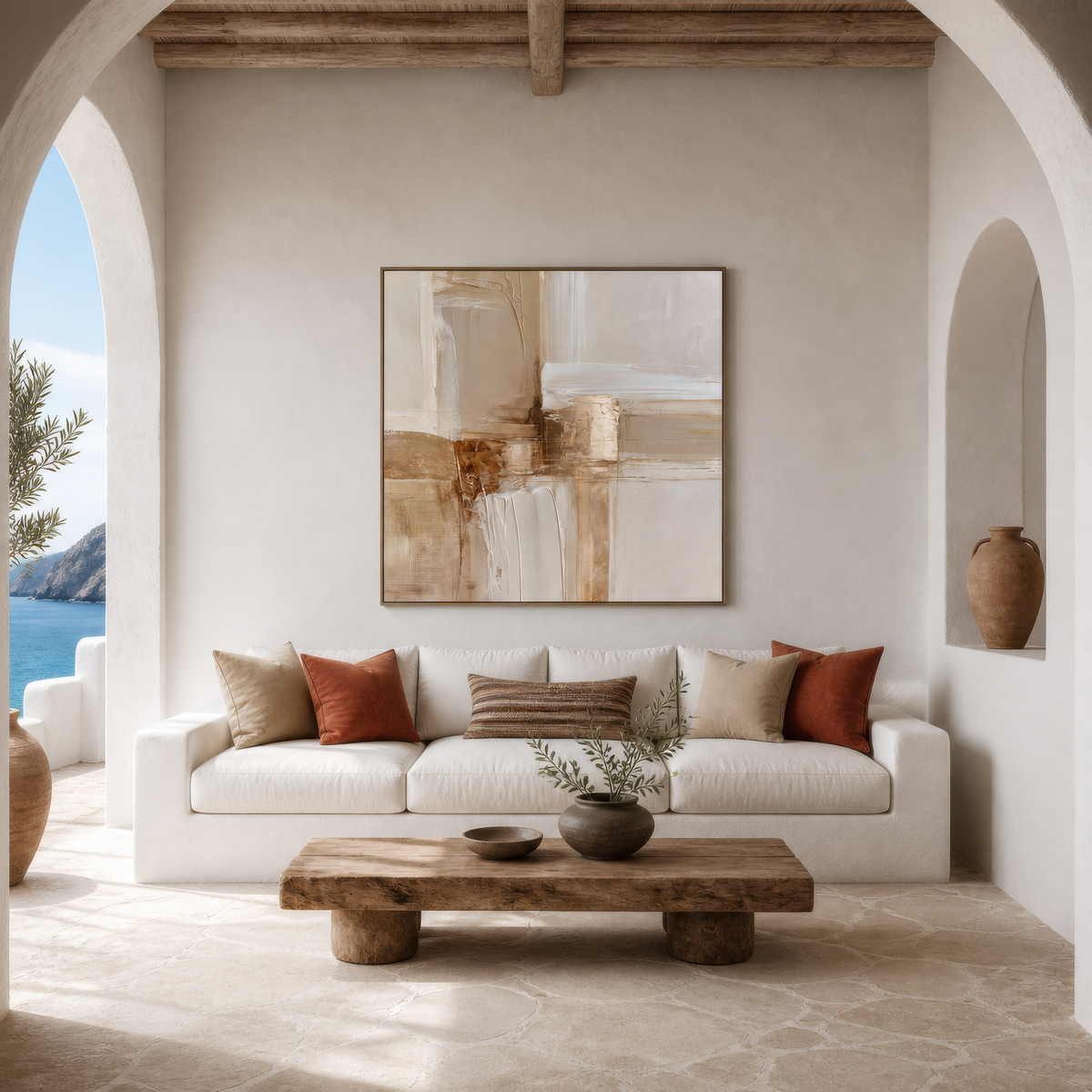 Square cream and copper abstract artwork above a white sofa beside an arched opening with a sea view