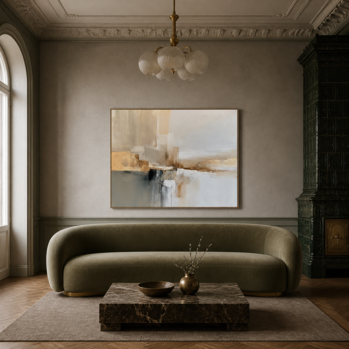 Large gray and gold abstract artwork above an olive curved sofa with a marble coffee table