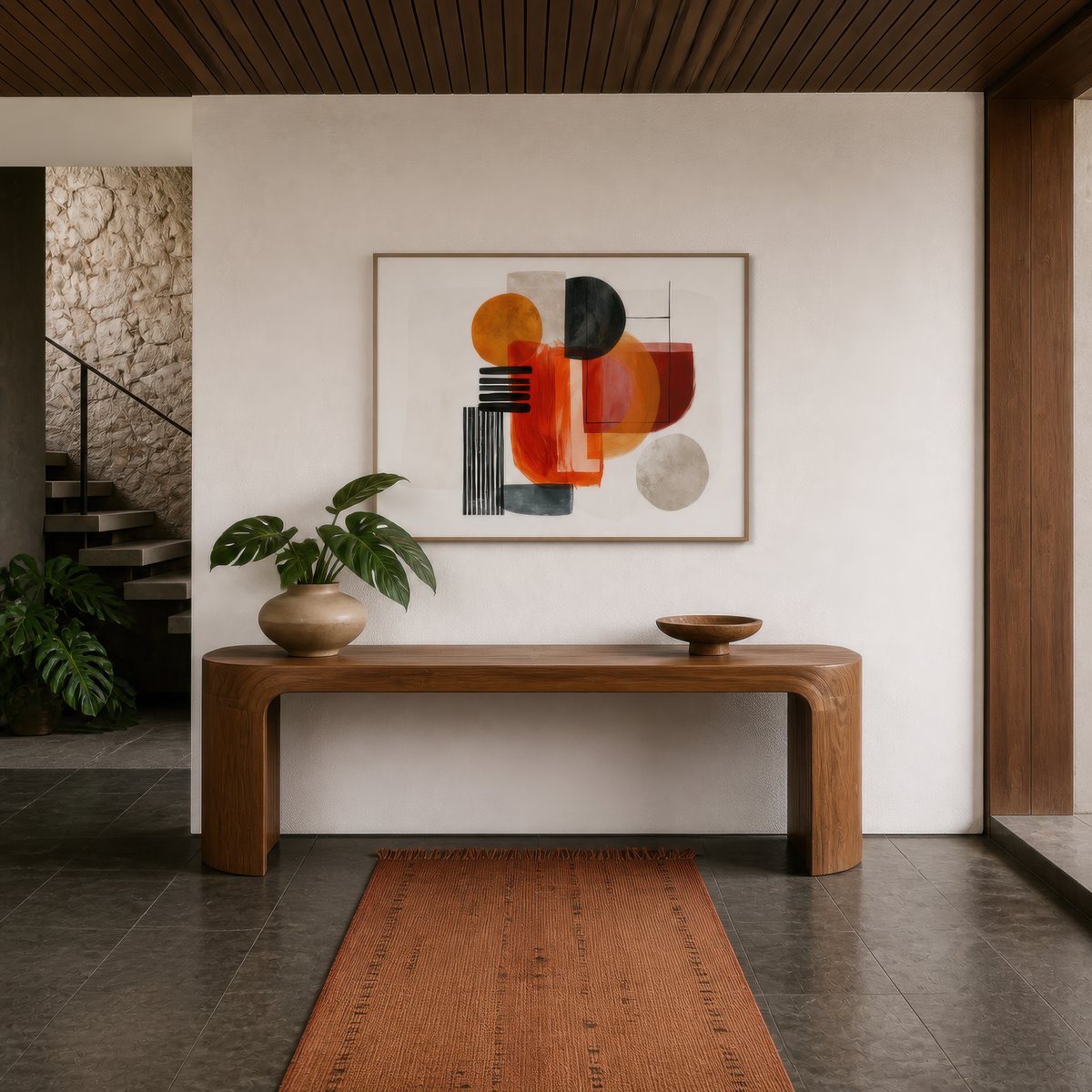 Bold shapes in terracotta above a wood console in an entryway with a plank floor