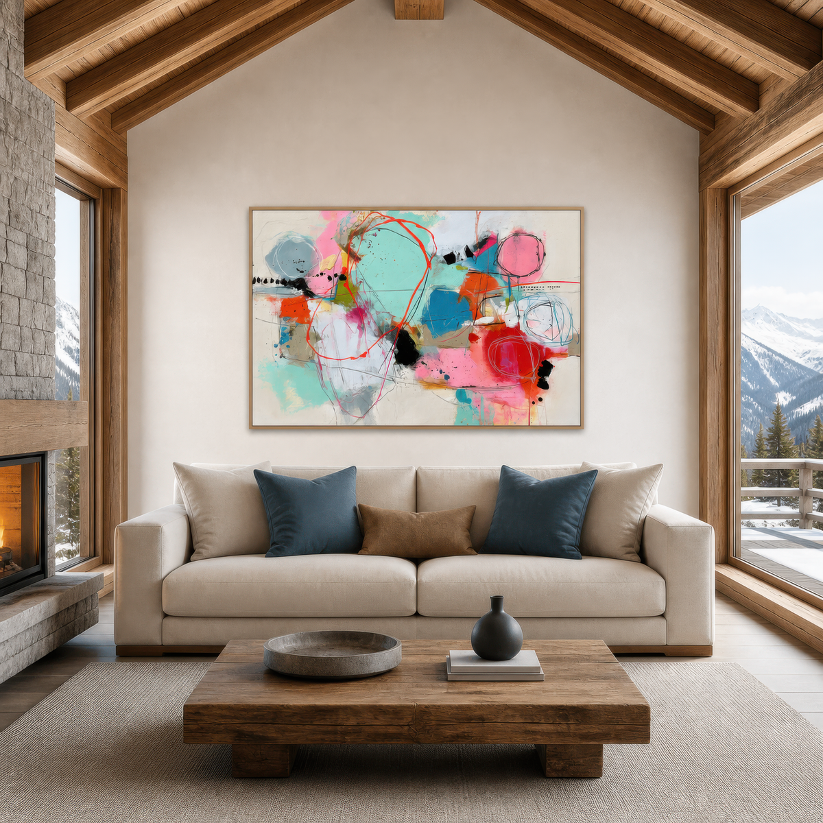 Pastel abstract collage above a cream sofa with blue pillows under an A-frame ceiling