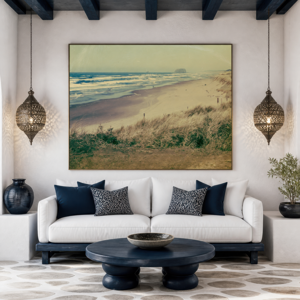 Dune grass beach at dawn above a white sofa with navy pillows and two pierced lanterns