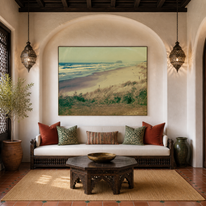 Dune grass beach at dawn above a low banquette with rust pillows under a plaster arch