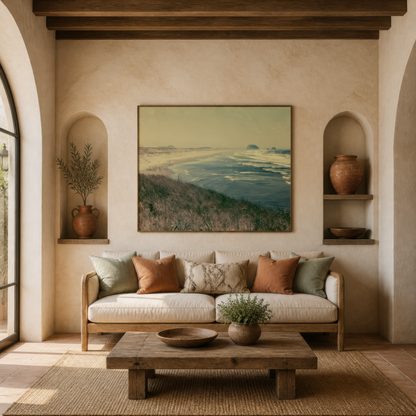 Vintage sea stack coastline above a cream sofa between two plaster arches with a low table