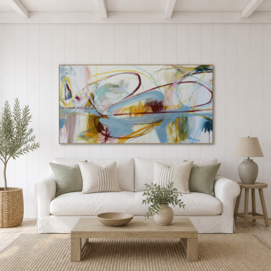 Wide burgundy and blue-gray abstract artwork above a white slipcovered sofa in a white living room