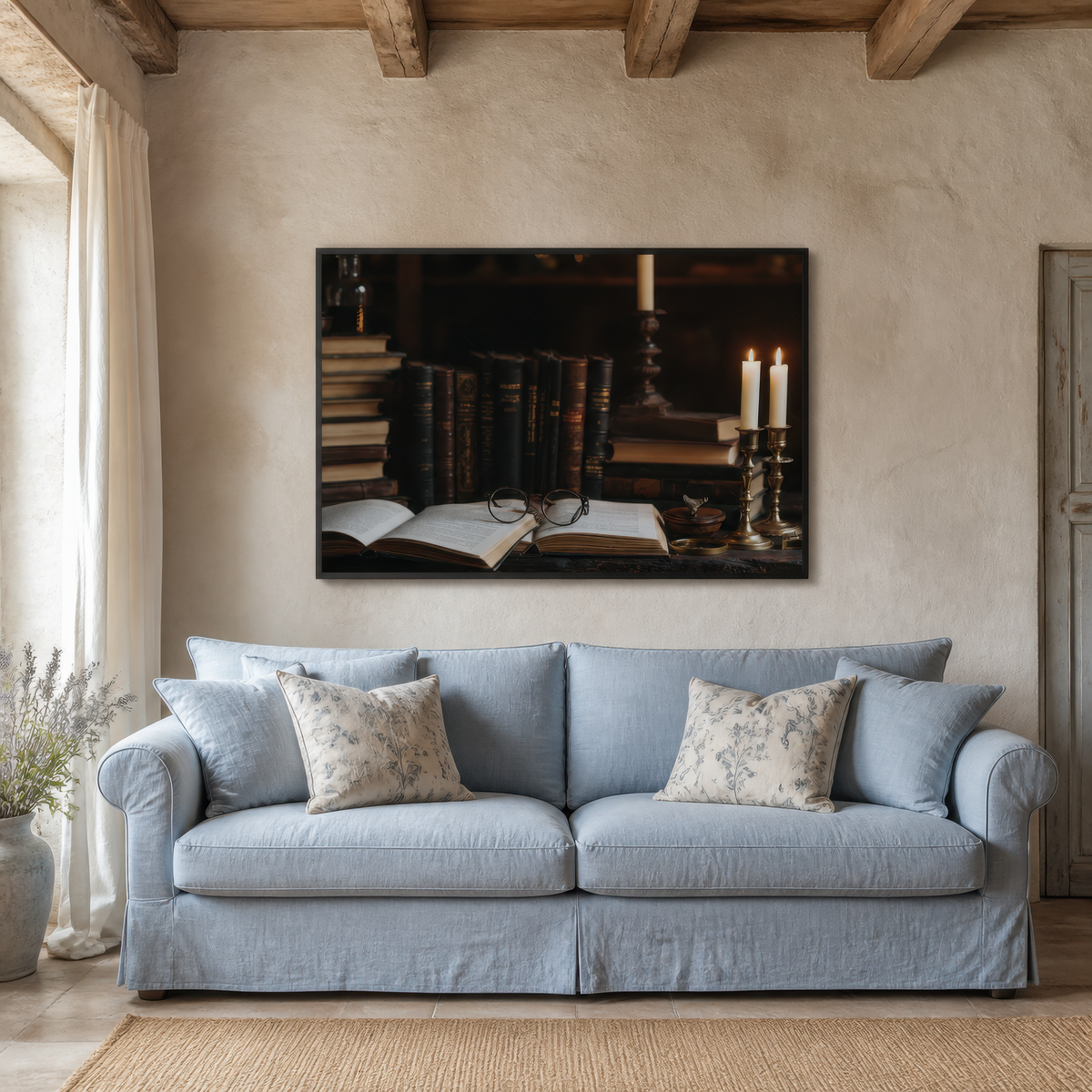 Candlelit folio above a pale blue slipcovered sofa on a cream plaster wall with wood beams