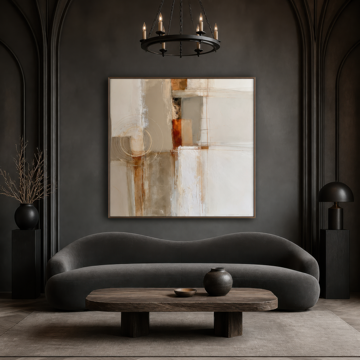Square russet and cream abstract artwork above a charcoal curved sofa on a dark wall with an iron chandelier