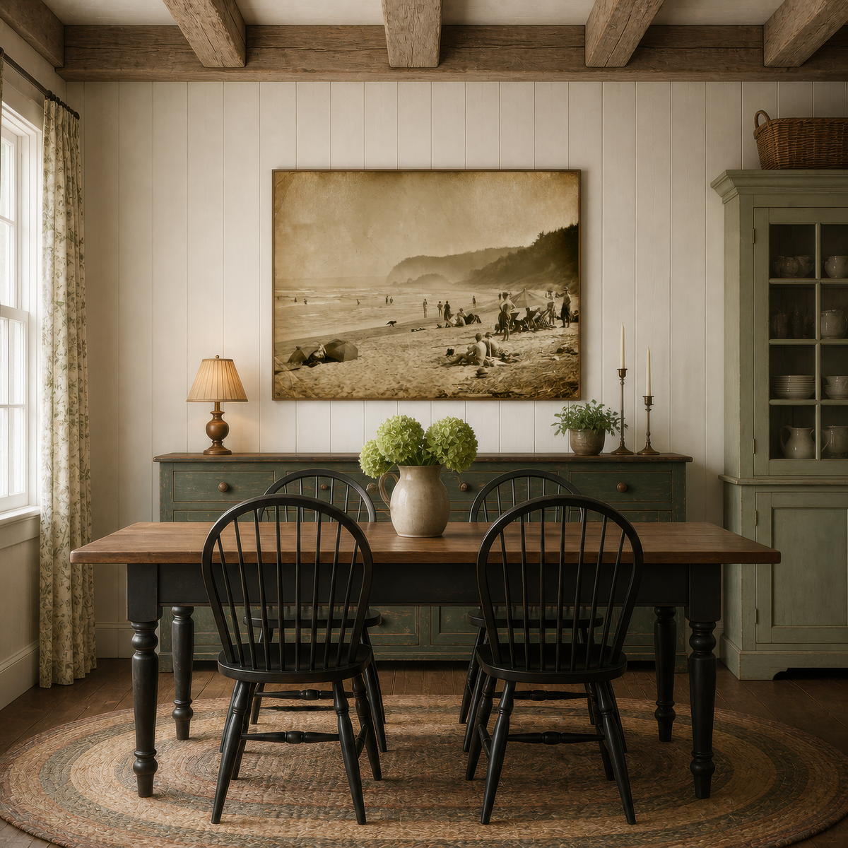 Sepia beach scene above a sage green sideboard with a dining table and Windsor chairs