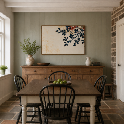 Branch with berries above a wood sideboard with a dining table and black spindle chairs