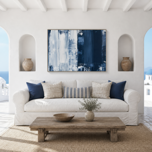 Large navy and white brushy abstract artwork above a white slipcovered sofa between arched wall niches