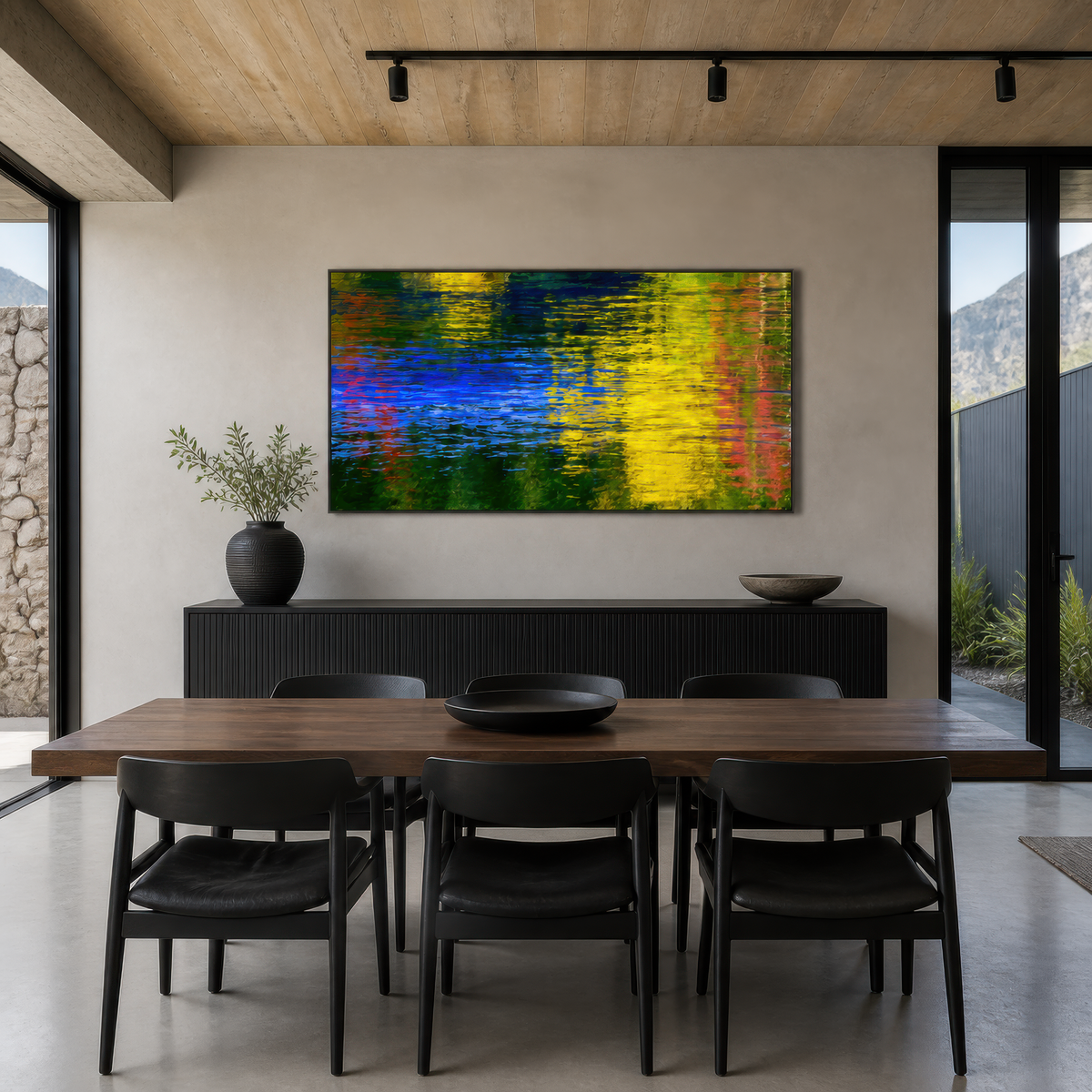 Autumn water reflection above a dark sideboard with a long dining table and black chairs