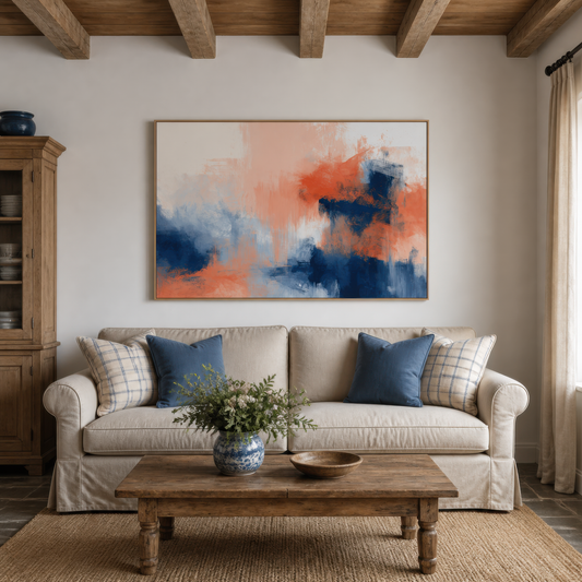 Large navy and coral abstract artwork above a white slipcovered sofa with navy pillows