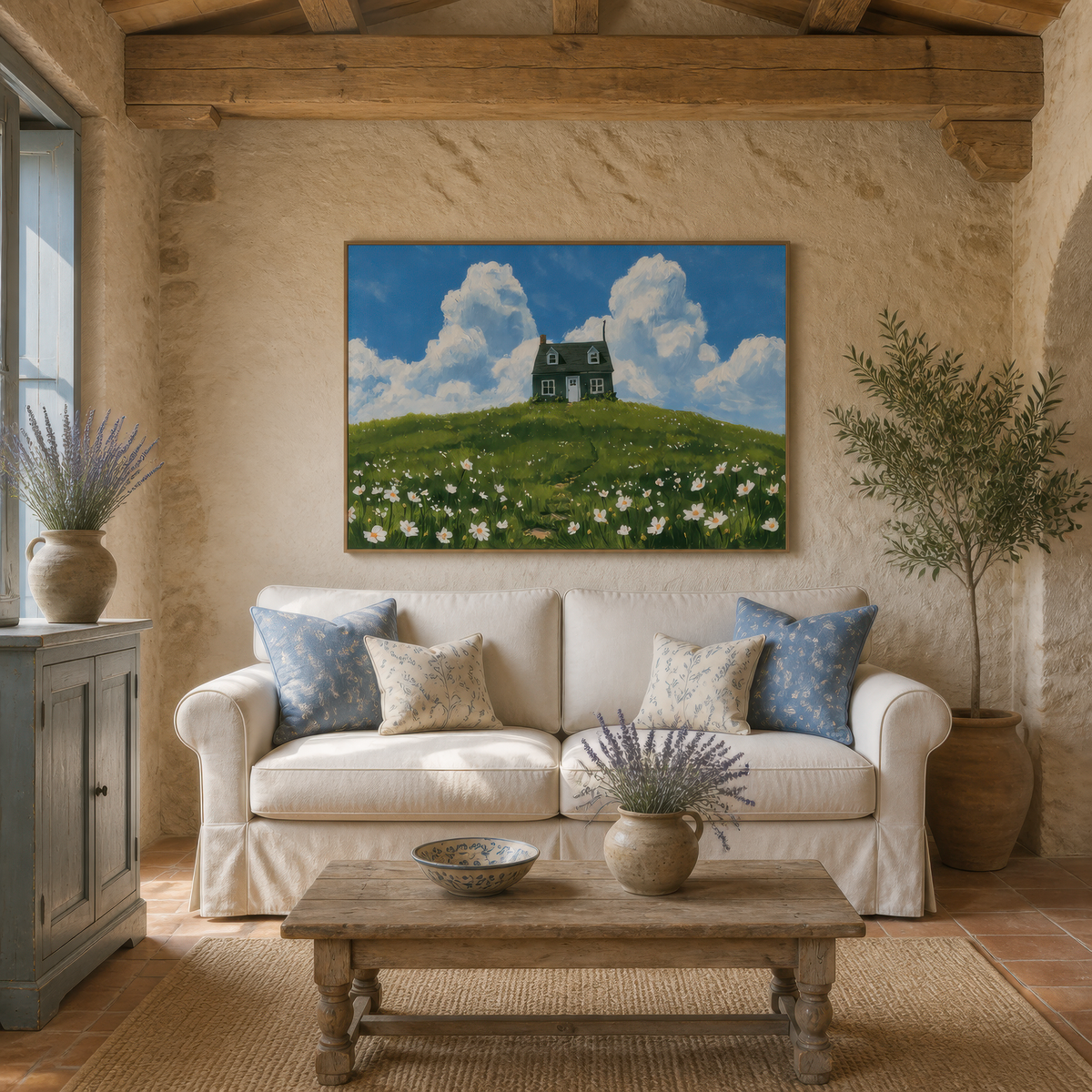 Cottage on the hill above a cream sofa with blue striped pillows on a sandstone wall